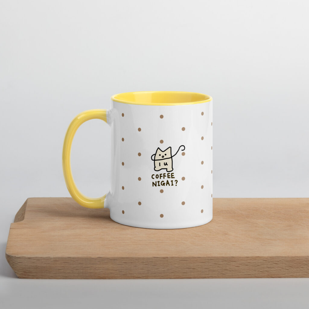 三浦小季さん描き下ろしのキャラクターをプリントした、黄色い持ち手のマグカップの裏面。
コーヒーを持った猫を描いた “coffee nigai?” デザイン。黄色い持ち手とドット柄が特徴。